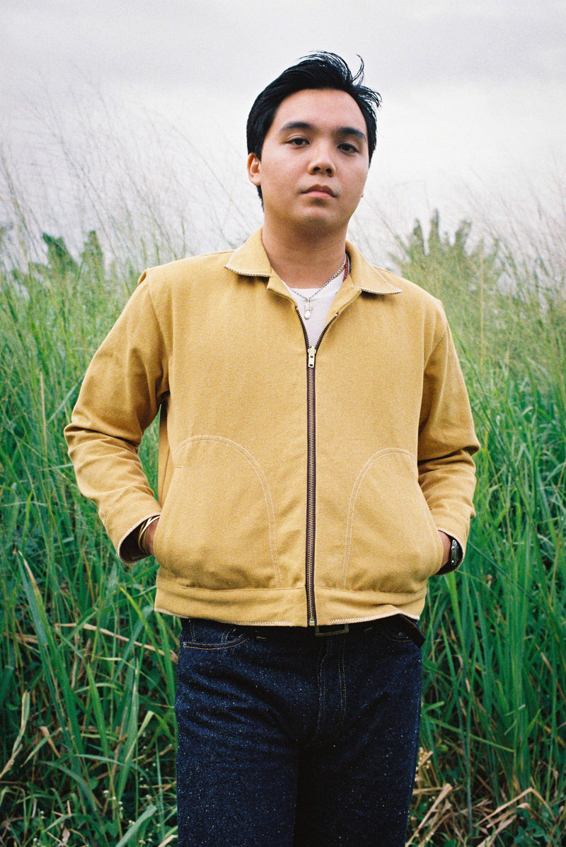 Person wearing a yellow jacket standing in a field of tall grass