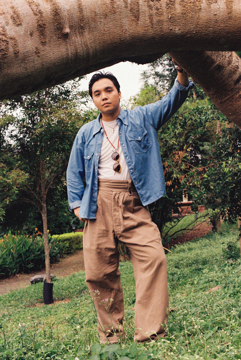 Person standing under a large tree in a garden