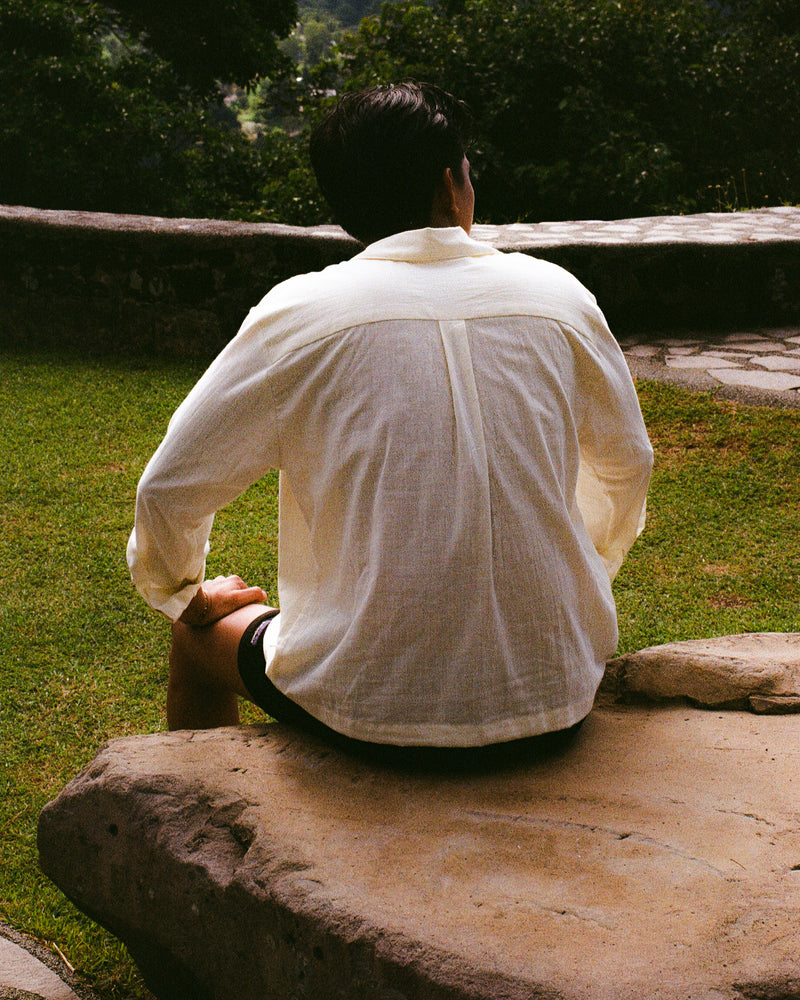 Person sitting on a stone bench in a park-like setting