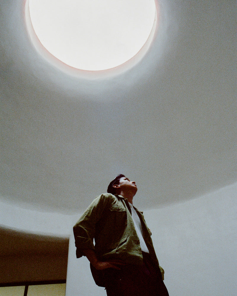 Person standing below a skylight in a building