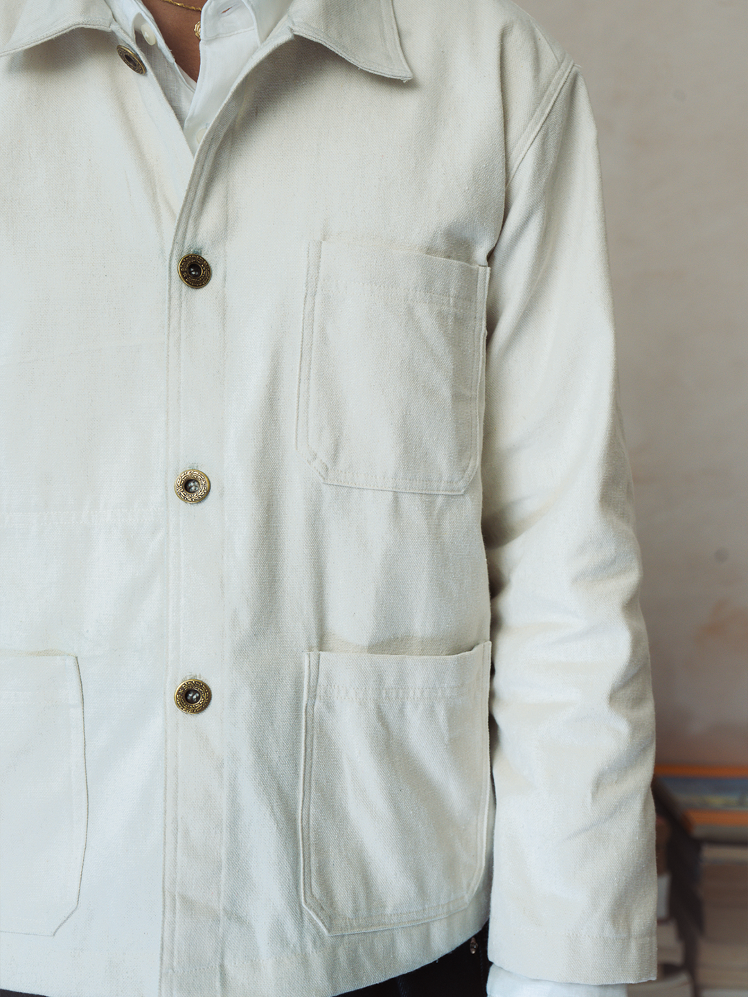 Close-up of a light-colored jacket with button details on a neutral background