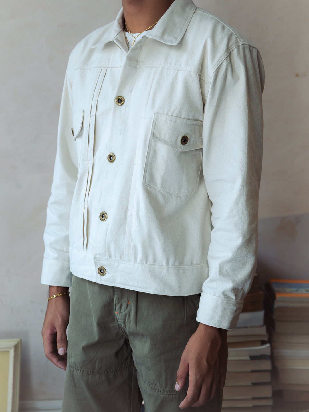 Person wearing a white type 2 trucker jacket with button details against a neutral background