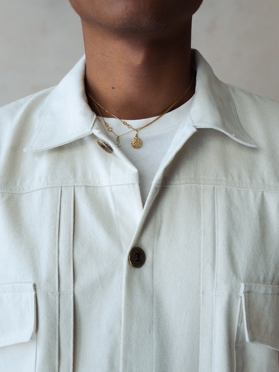 White type 2 trucker jacket with a collar and buttons, worn by a person, on a neutral background.