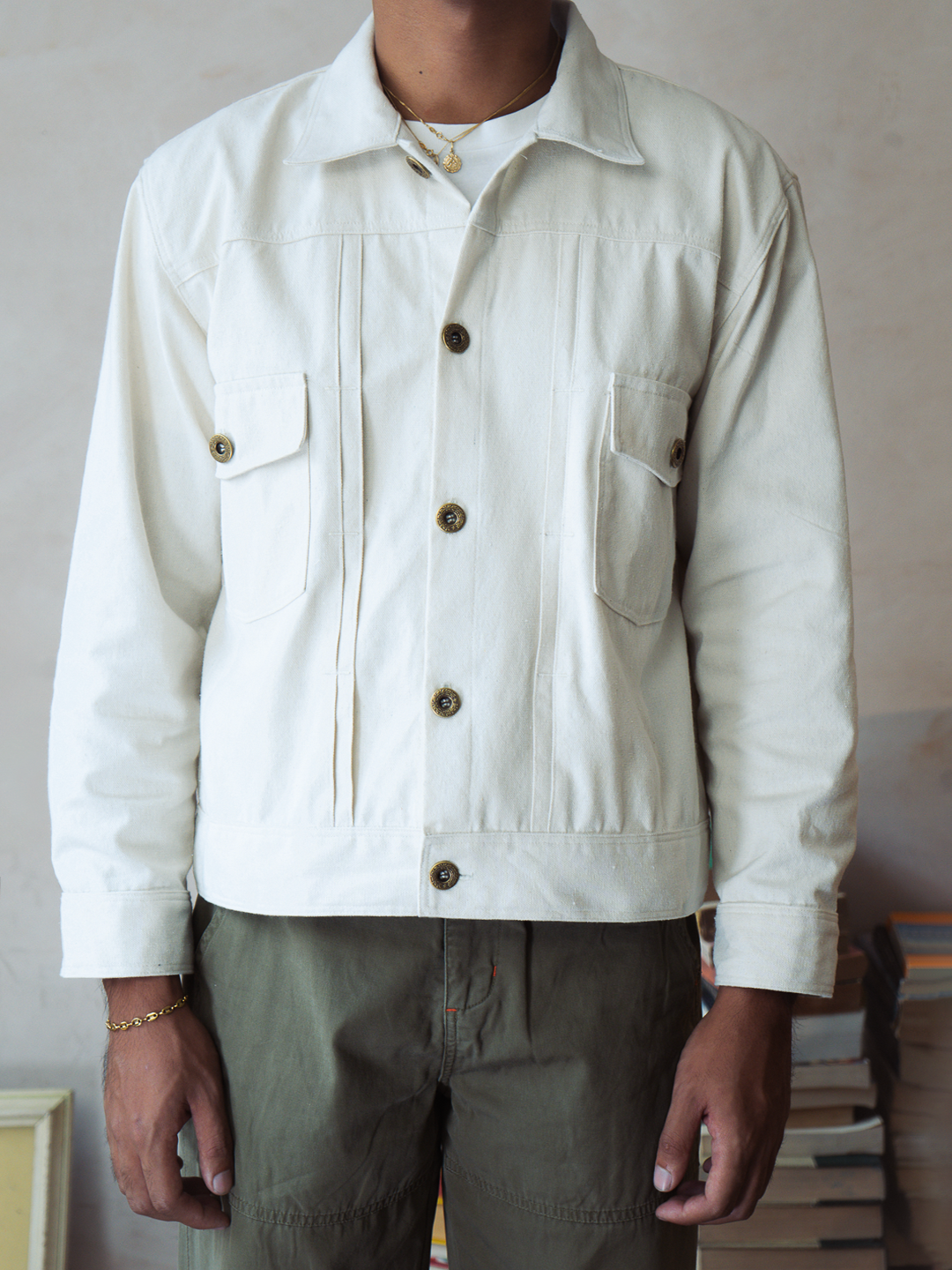 Person wearing a white type 2 trucker jacket with button details against a neutral background
