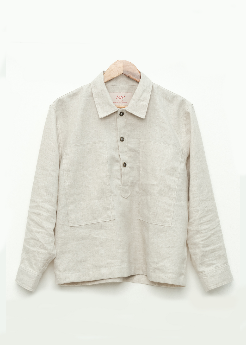 medium weight linen pullover shirt on a hanger against a white background