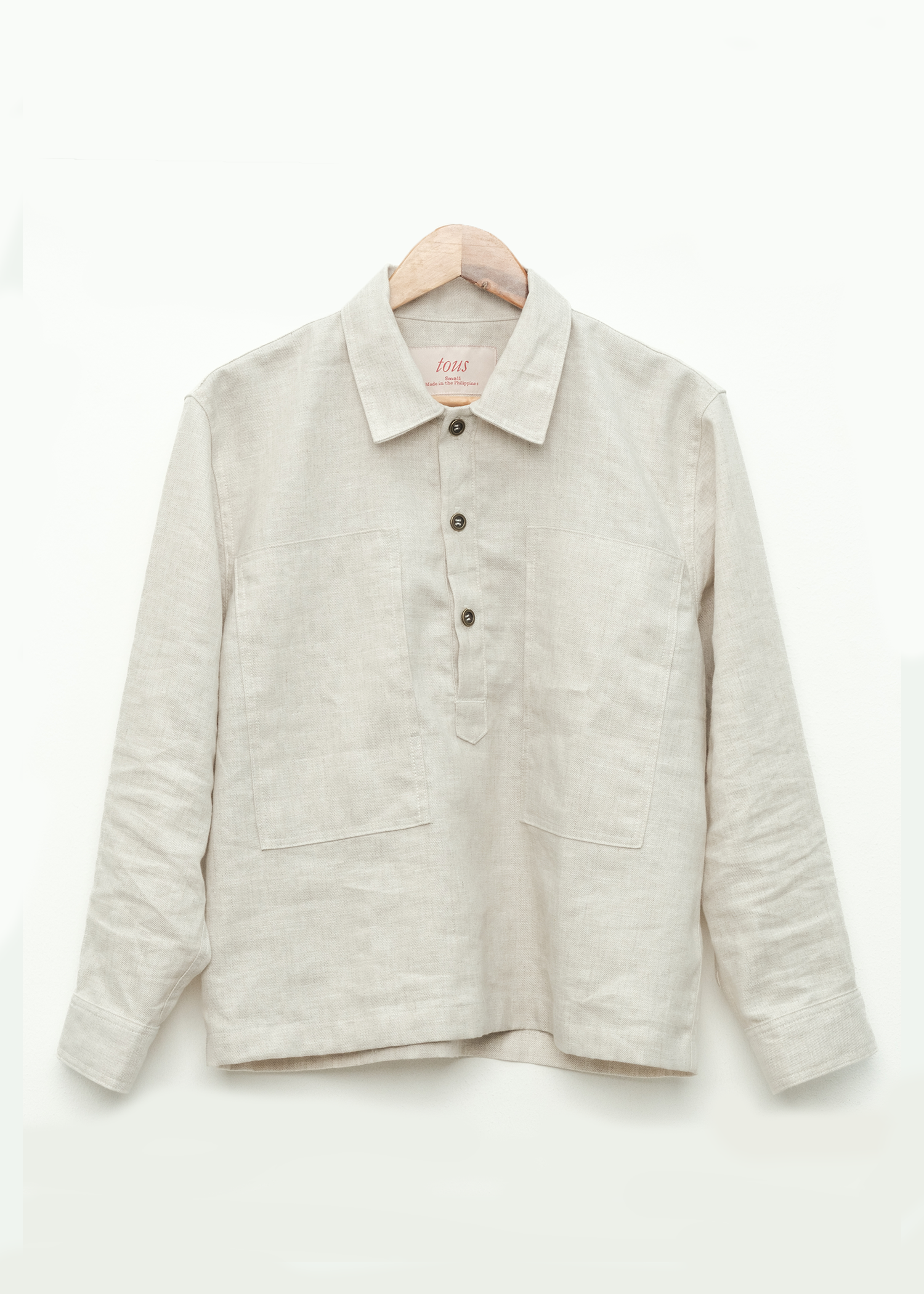 medium weight linen pullover shirt on a hanger against a white background