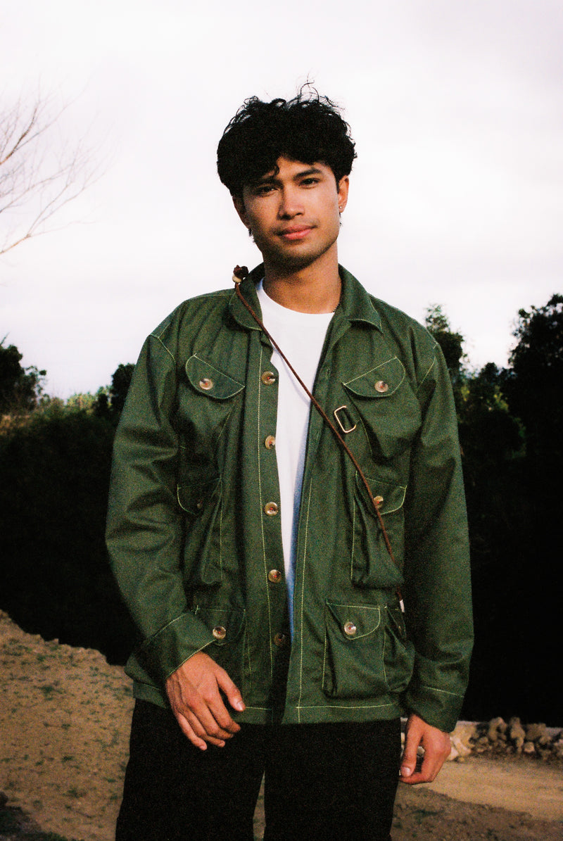 Person wearing a tous gardening jacket outdoors with trees and sky in the background