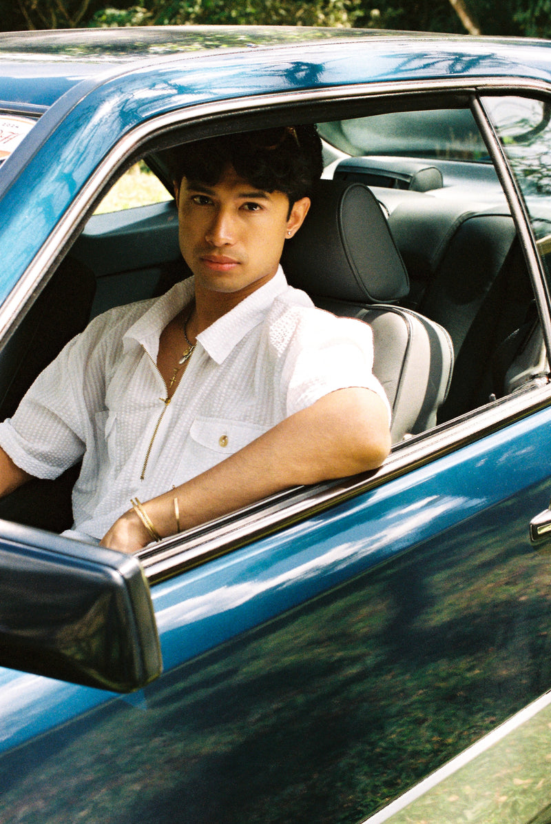 Man sitting in a car with a scenic background