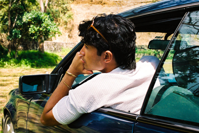 Person leaning out of a car window in a natural setting